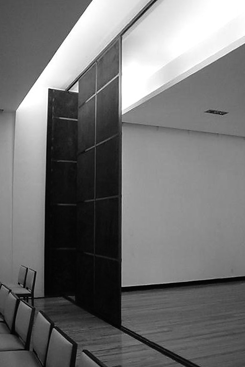 Corredor con muro oscuro a doble altura
