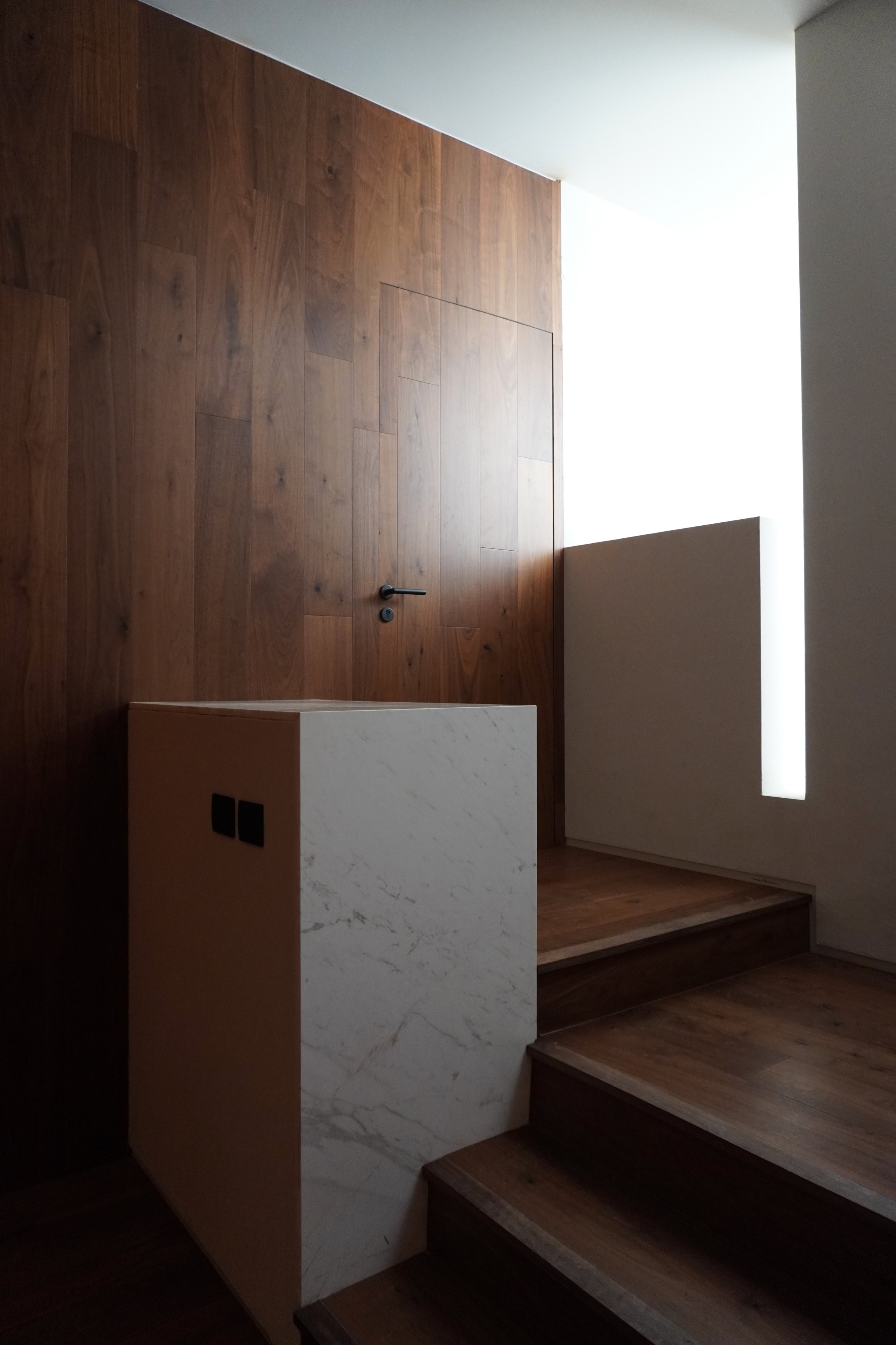 El paso entre el muro de madera y el volumen blanco