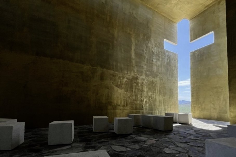El interior, con la cruz de luz sobre el muro de tierra