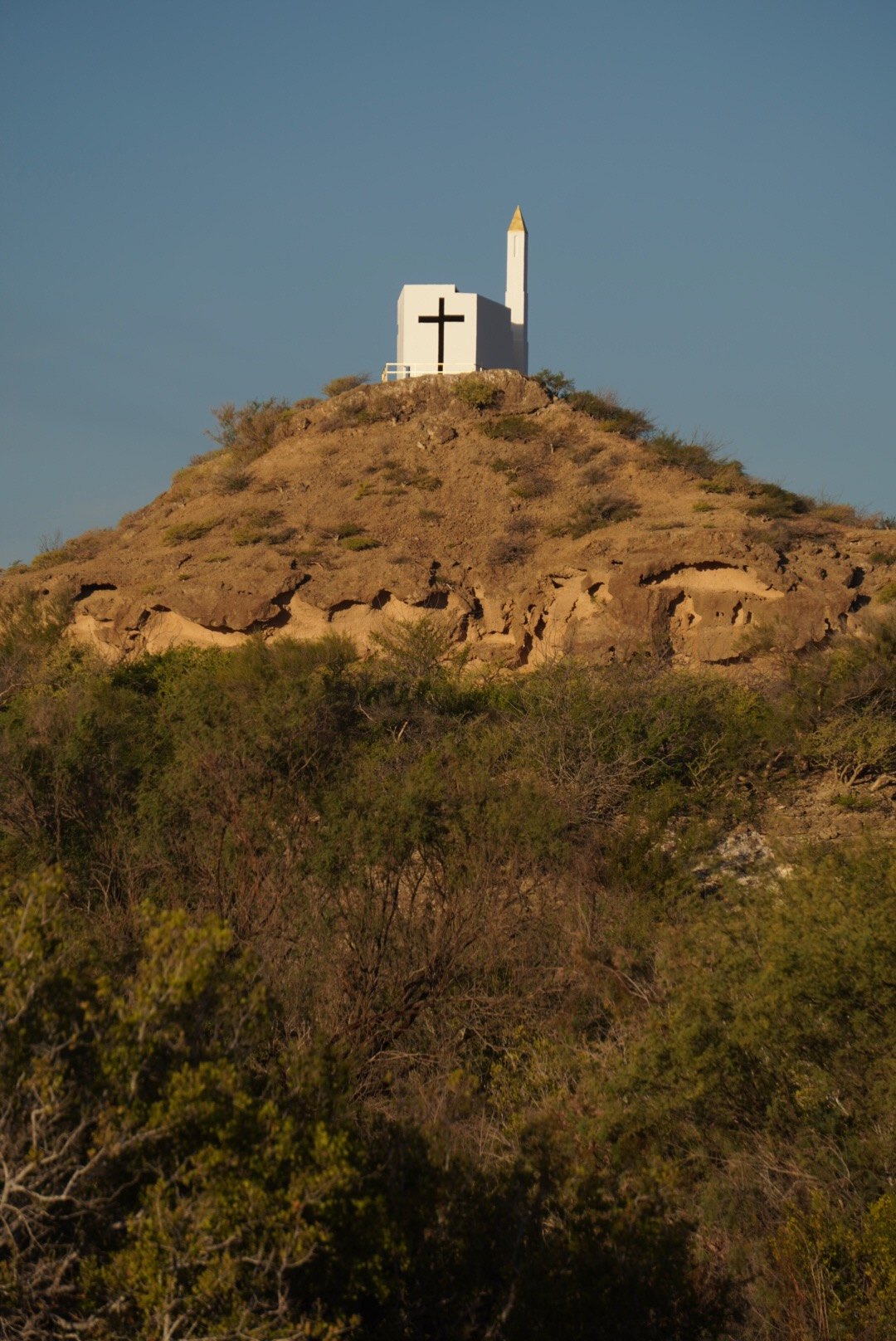 La capilla en lo alto del cerro, entre la vegetación seca
