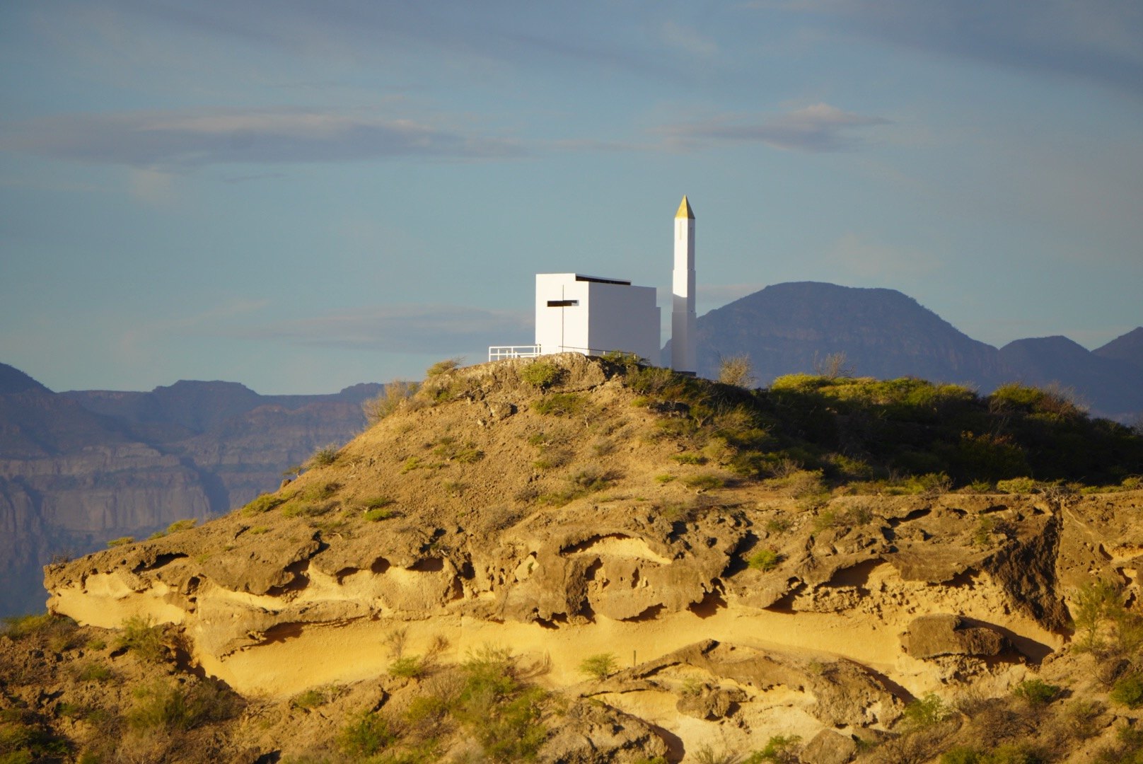 El cerro y la capilla al atardecer, con la sierra detrás