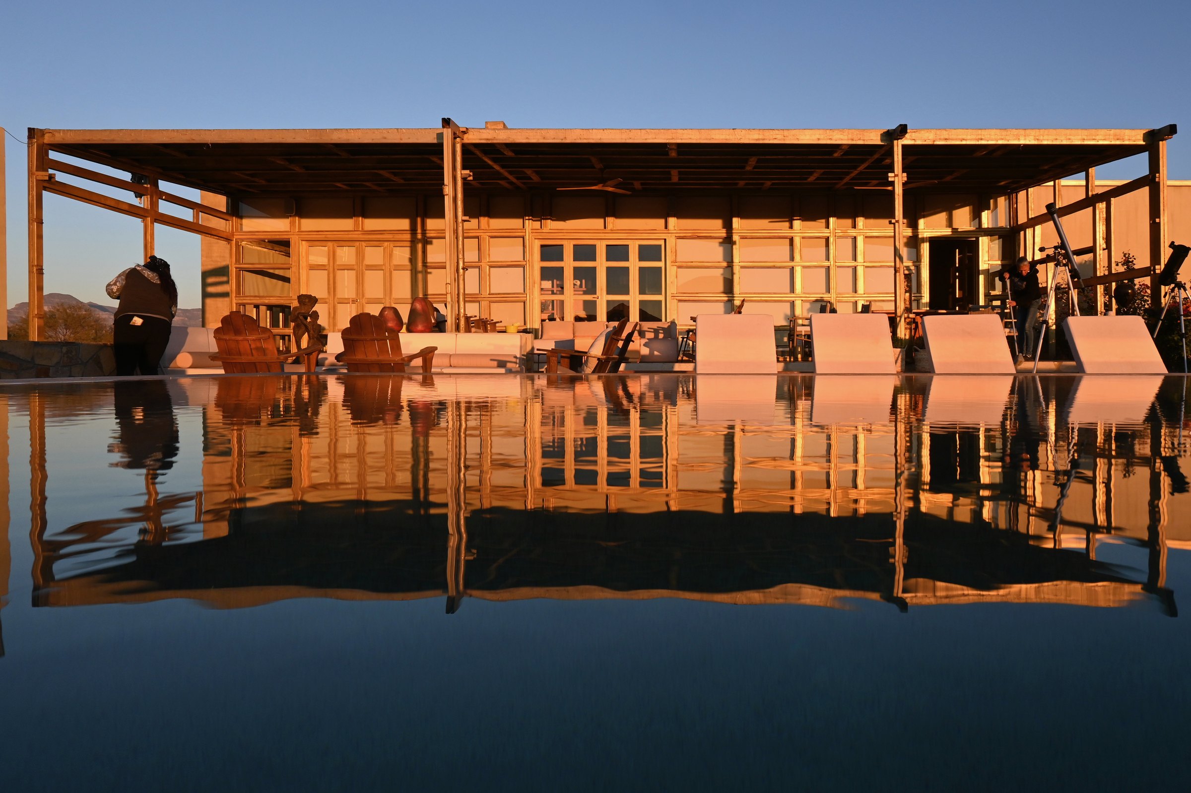 La pérgola reflejada en el agua, con las sillas alineadas