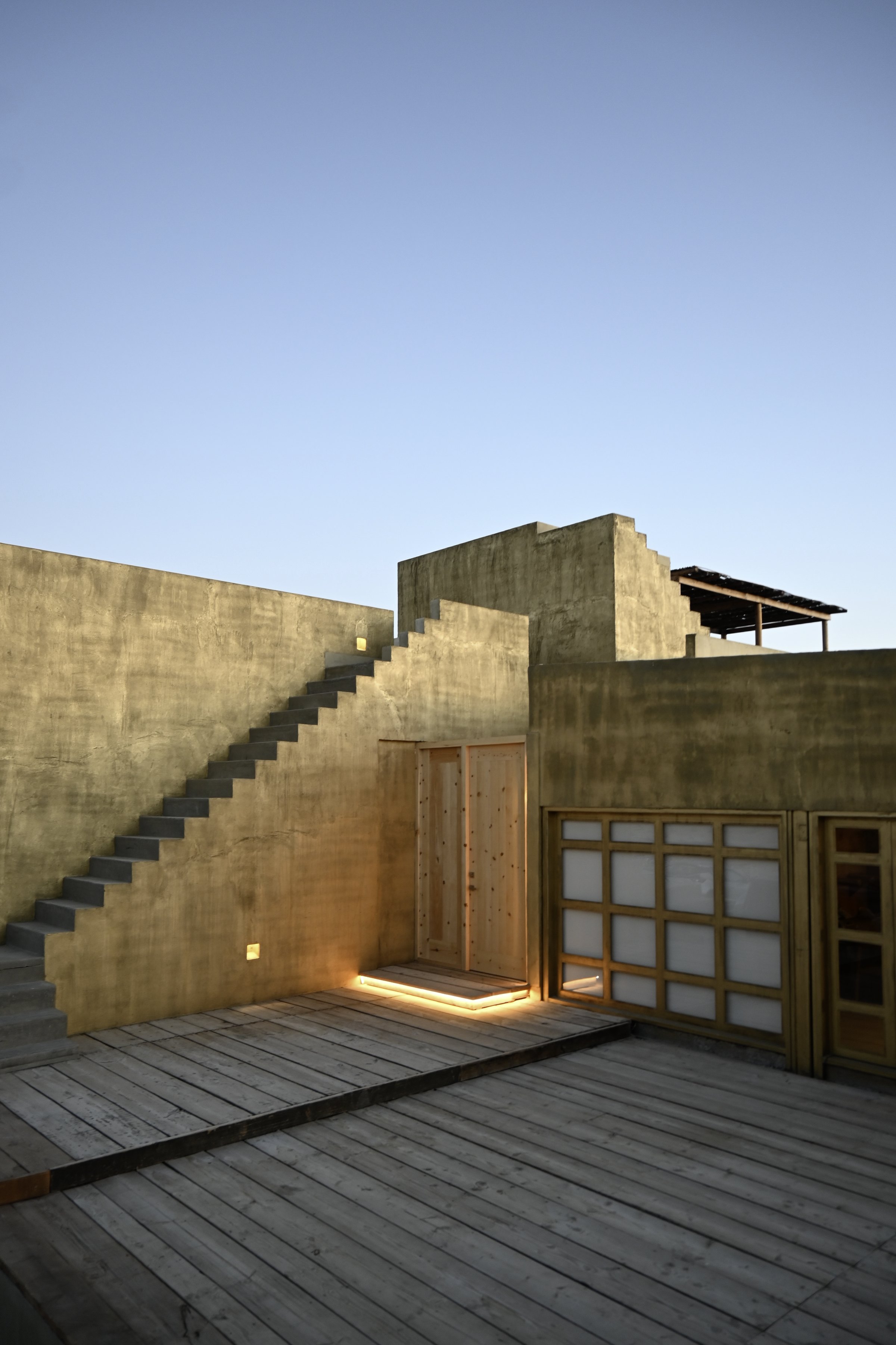 La escalera exterior y la terraza de madera, contra el cielo