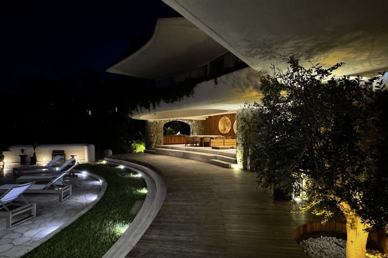 La casa encendida de noche entre la vegetación