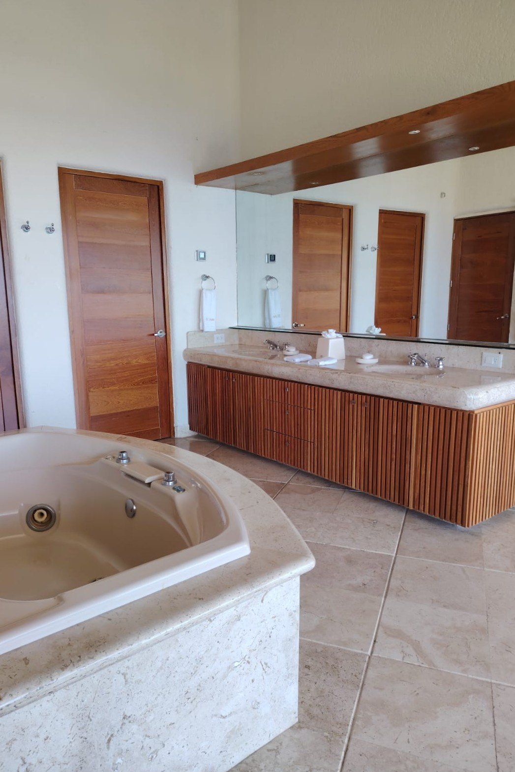 Baño con tina y doble lavabo de madera