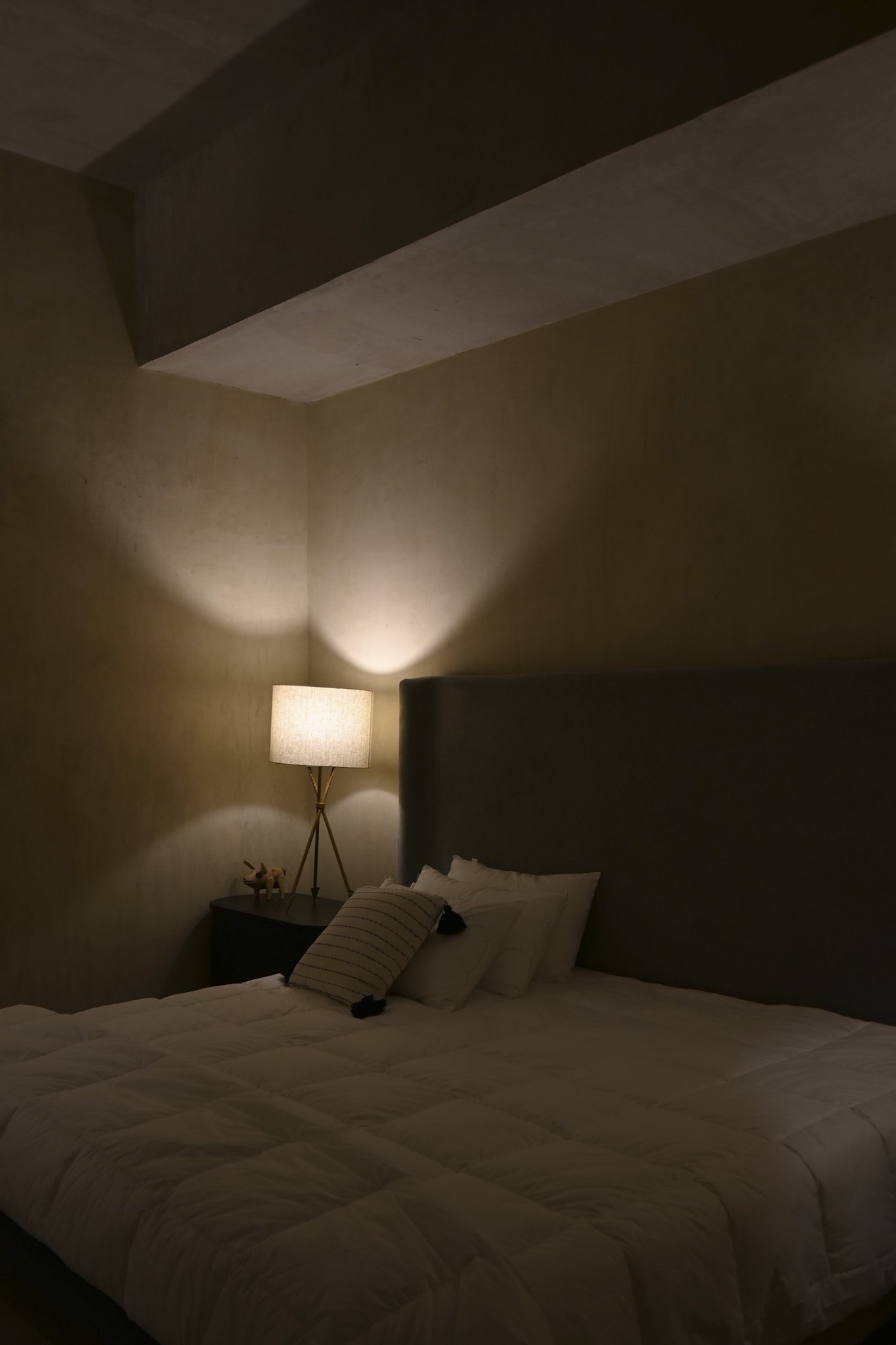 Recámara con la cama vestida y la luz cálida