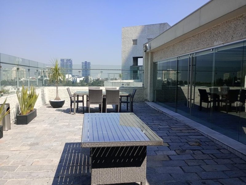 Terraza común con los comedores y la ciudad detrás