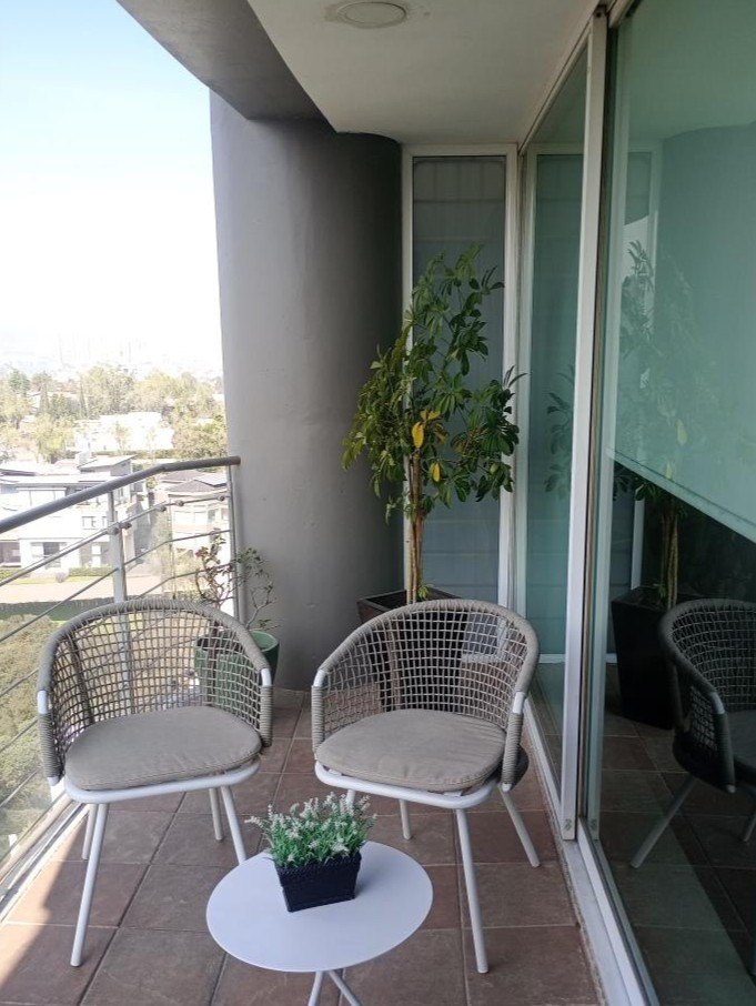 Balcón con dos sillones y la vegetación al fondo